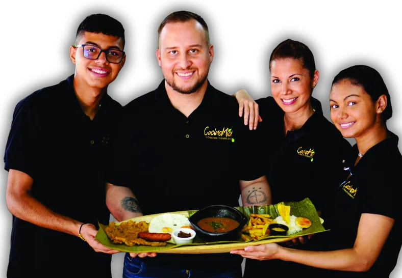 La familia de Cocinamia sostiene una bandeja servida sobre hoja de plátano